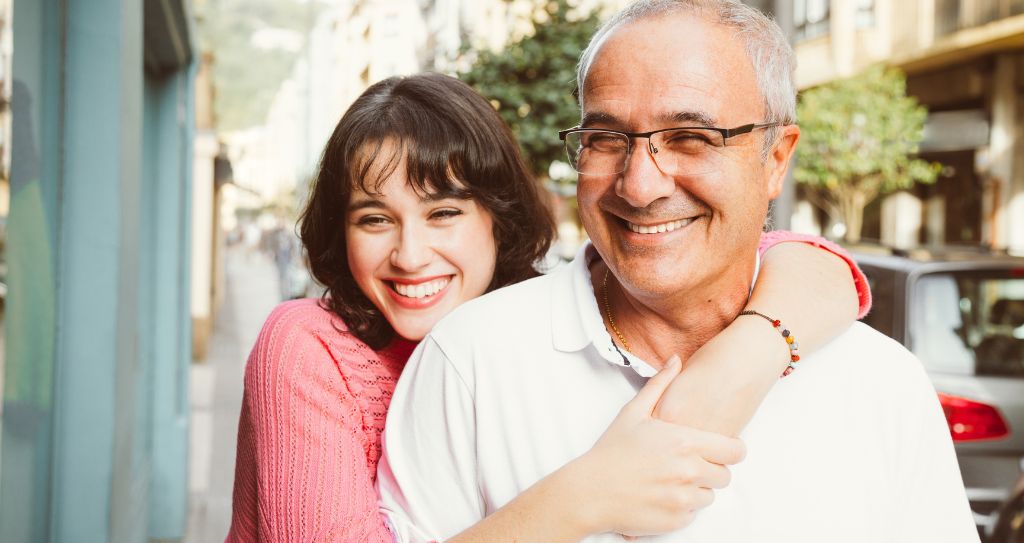 Pai e filha sorrindo e abraçados na rua, mostrando a importância de escolher o que vender no Dia dos Pais para encantar famílias.