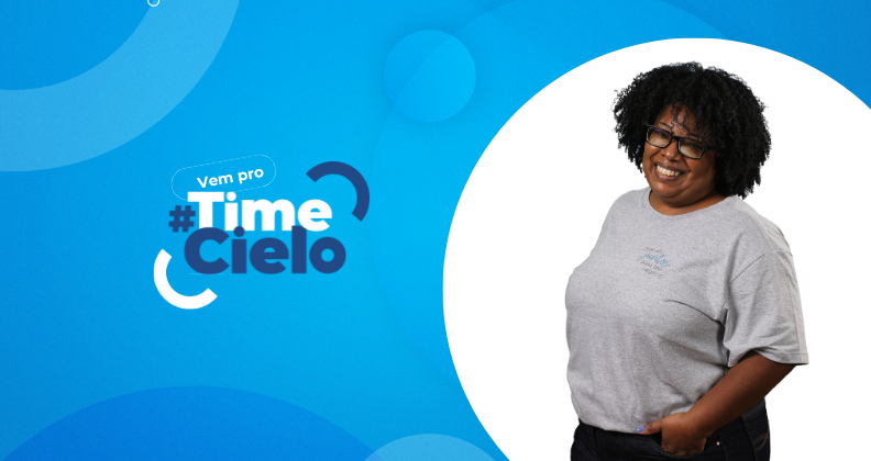 Banner em fundo azul com elementos gráficos circulares e o texto ‘Vem pro #TimeCielo’, ao lado da imagem de uma pessoa em pé vestindo camiseta cinza, representando convite para oportunidades de carreira na Cielo.