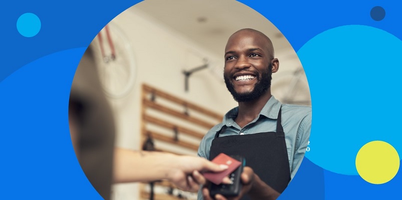 Empreendedor sorridente negro faz pagamento por aproximação de cliente em máquina que não precisa de celular.