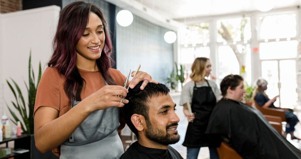 Profissional de salão de beleza atendendo cliente, representando como calcular margem de lucro de um serviço é importante para a sustentabilidade do negócio.