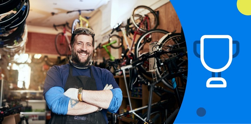 Empreendedor de sucesso do ramo de bicicletas com largo sorriso e braços cruzados.