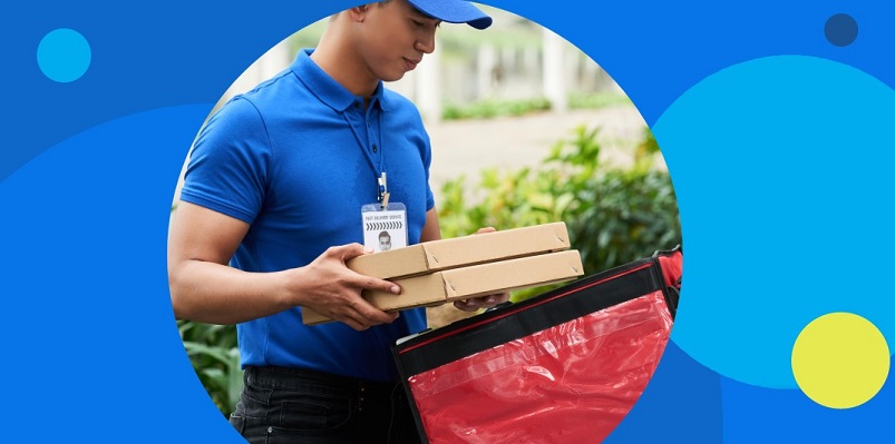 Homem de camisa e boné azul faz entrega de pedido vendido pelo iFood.