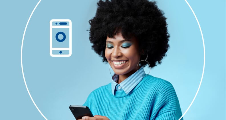 Empreendedora de cabelos afro sorri ao olhar para o seu celular, que agora tem a tecnologia tap on phone e aceita pagamentos por aproximação.
