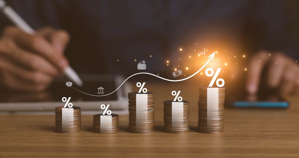 Representação visual de crescimento financeiro ligado ao planejamento tributário, com pilhas de moedas e ícones de percentual.