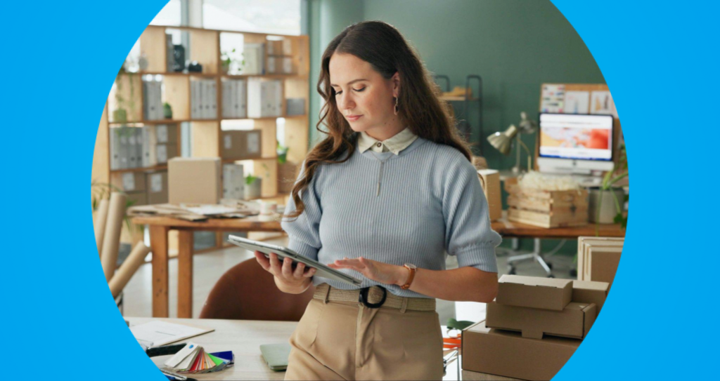 Mulher empreendedora em ambiente de trabalho verificando informações em um tablet, refletindo a fase de qualificação no ciclo de vendas, quando os empreendedores avaliam o interesse do cliente e preparam o processo de compra.