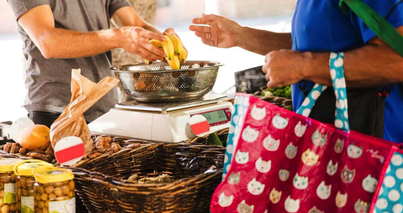MEI recebendo pagamento de cliente na feira livre com maquininha.