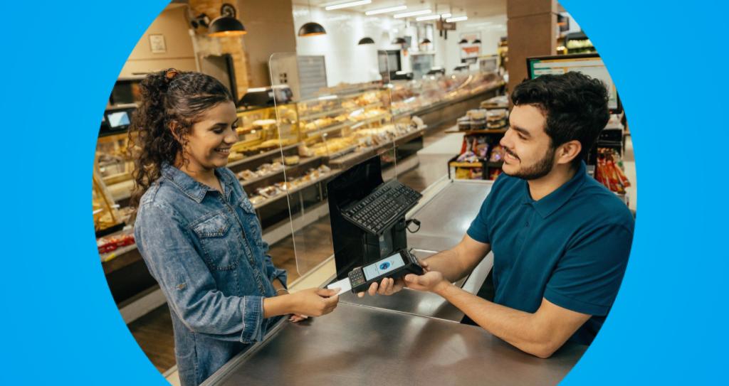 Foto de um cliente realizando o pagamento com cartão de crédito ou débito em uma maquininha Cielo, destacando o uso da tecnologia de pagamentos para transações rápidas e seguras, com a taxa MDR aplicada.