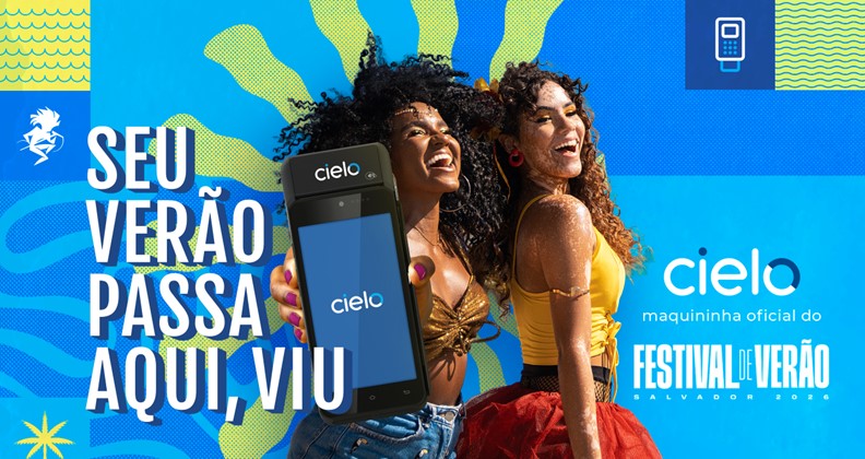 "Imagem promocional colorida da Cielo para o Festival de Verão de Salvador 2026, com duas pessoas posando juntas em roupas de verão. À esquerda, o texto 'Seu verão passa aqui, viu' aparece ao lado de uma maquininha de pagamento da Cielo. À direita, estão os logos da Cielo e do Festival de Verão sobre um fundo vibrante com formas e cores tropicais."