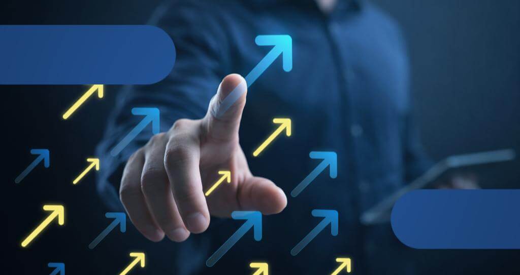 Detalhe de mão masculina apontando para cima, com diversas setas também em movimento de crescimento, indicando como aumentar taxa de conversão de vendas.