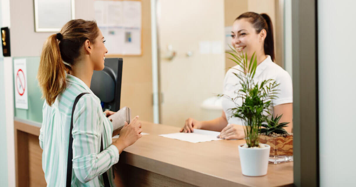 atendendo paciente em clínica médica, realizando pagamento com maquininha integrada para a área da saúde.