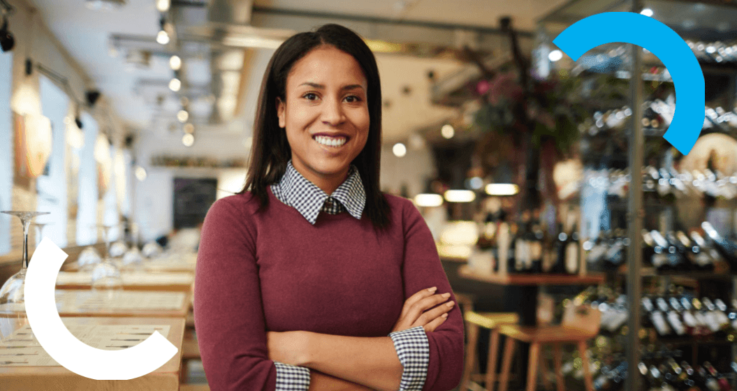 Empreendedora de braços cruzados em restaurante usando antecipação de recebíveis Cielo para equilibrar o fluxo de caixa.