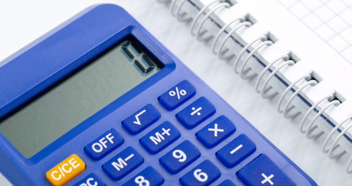 calculadora azul com caderno quadriculado representando controle financeiro e cálculo de inadimplência.