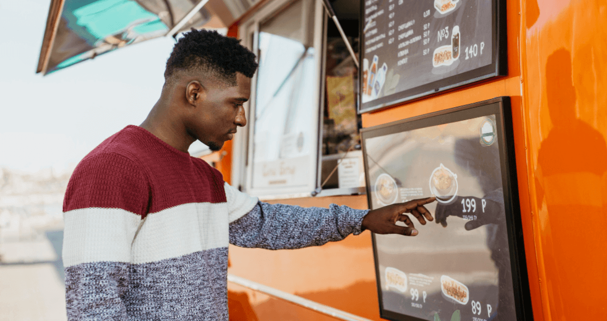 Um homem analisa o cardápio de um food truck