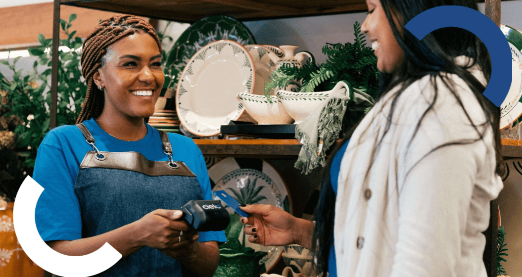 empreendedora sorri ao receber pagamento com maquininha cielo em loja de decoração.