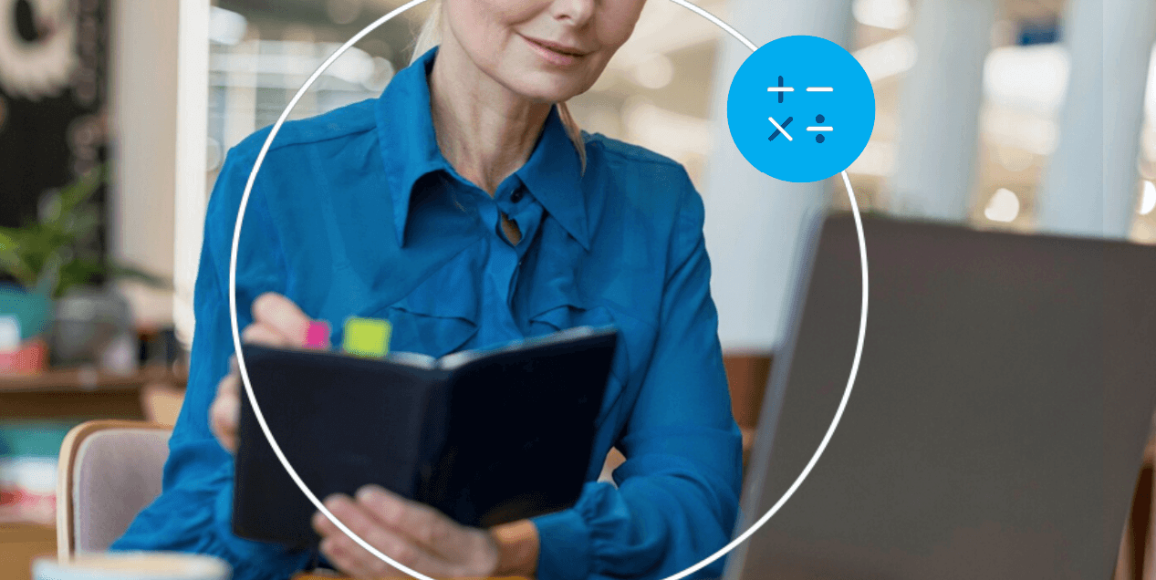 empreendedora consultando caderno de anotações ao lado de notebook em cafeteria.