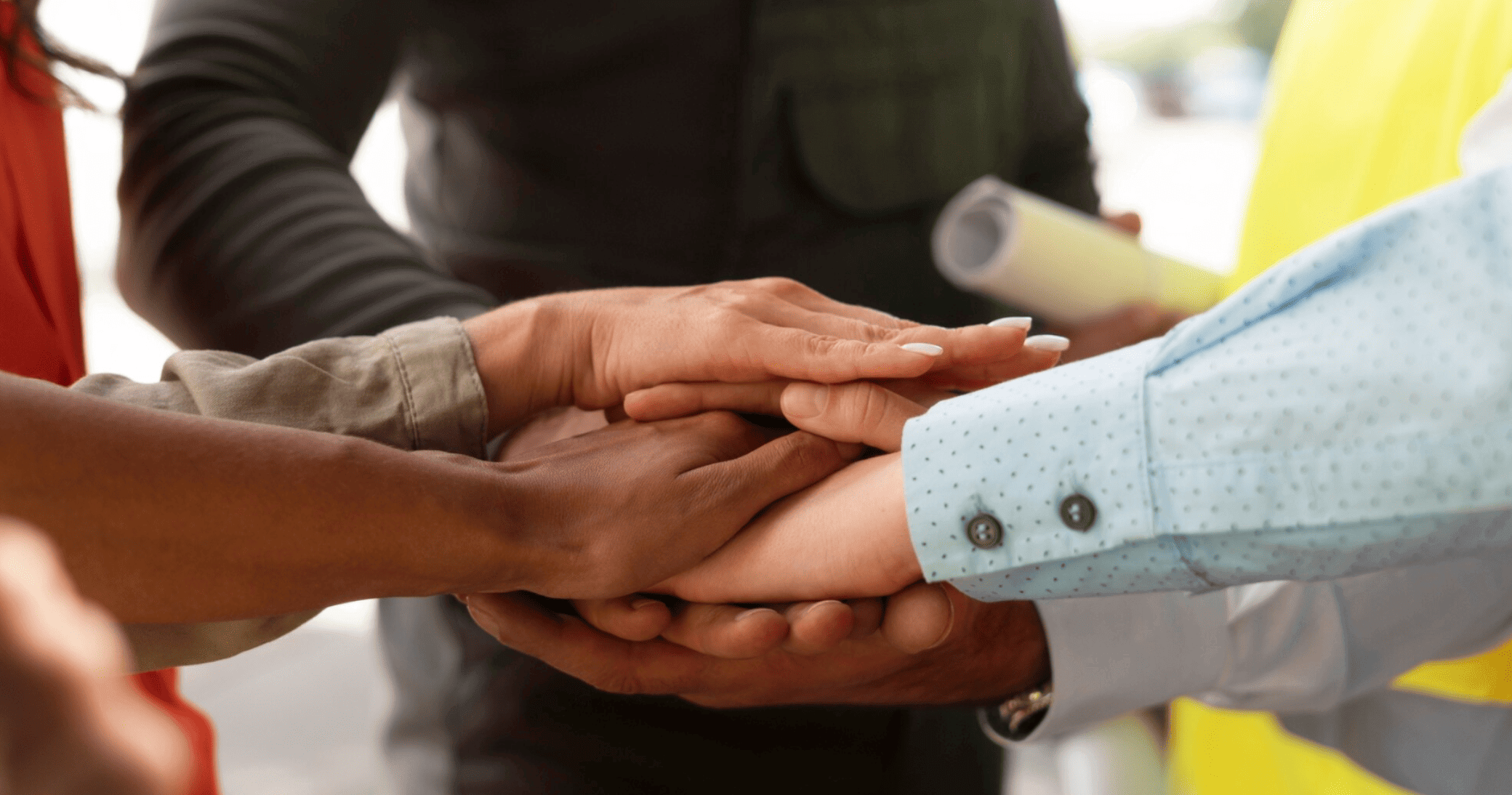 mãos de pessoas diversas unidas em gesto de solidariedade e comunidade.