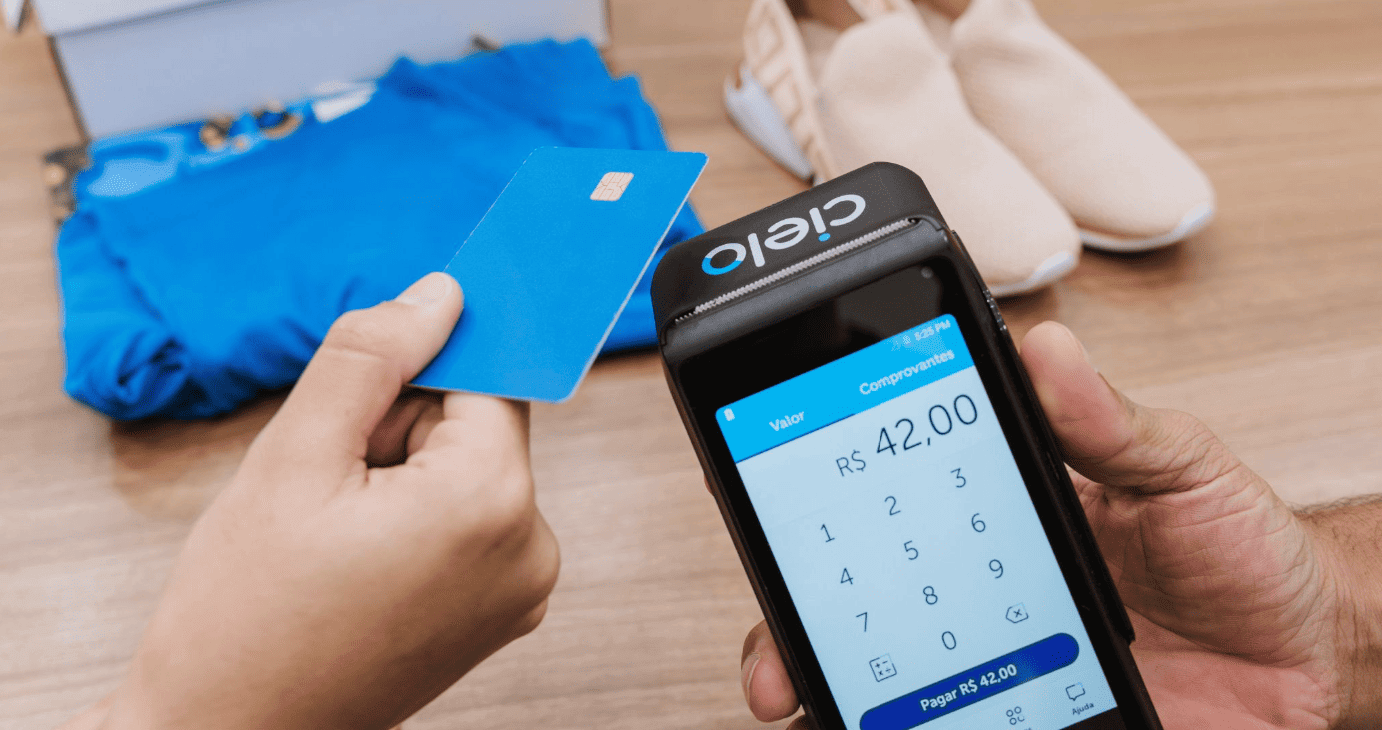 Maquininha de cartão Cielo recebendo pagamento por aproximação com cartão.