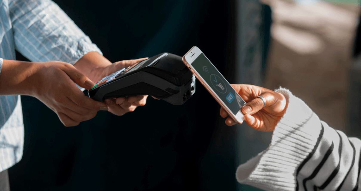 cliente aproximando smartphone com carteira digital de maquininha para pagamento nfc.
