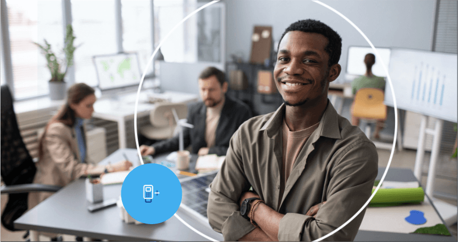 profissional liberal sorrindo de braços cruzados em escritório com equipe ao fundo e ícone de maquininha.