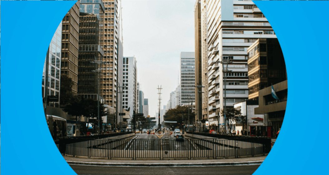 A imagem mostra a Avenida Paulista, em São Paulo, vista de frente entre grandes prédios.