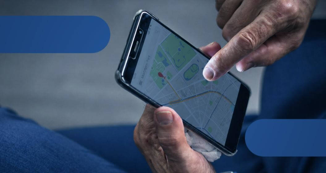 Pessoa segurando um smartphone com aplicativo de mapa e localização aberto na tela.