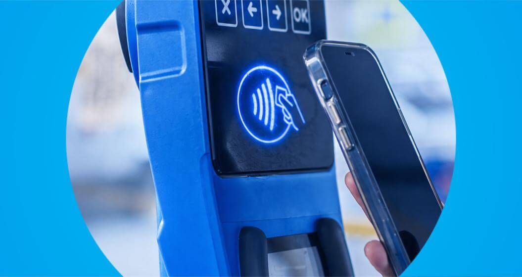 Indivíduo com um celular próximo a um parquímetro de cor azul.