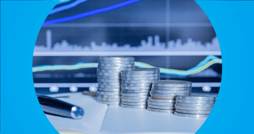 Pilhas de moedas posicionadas em frente a um gráfico financeiro, representando crescimento de investimentos e juros compostos.