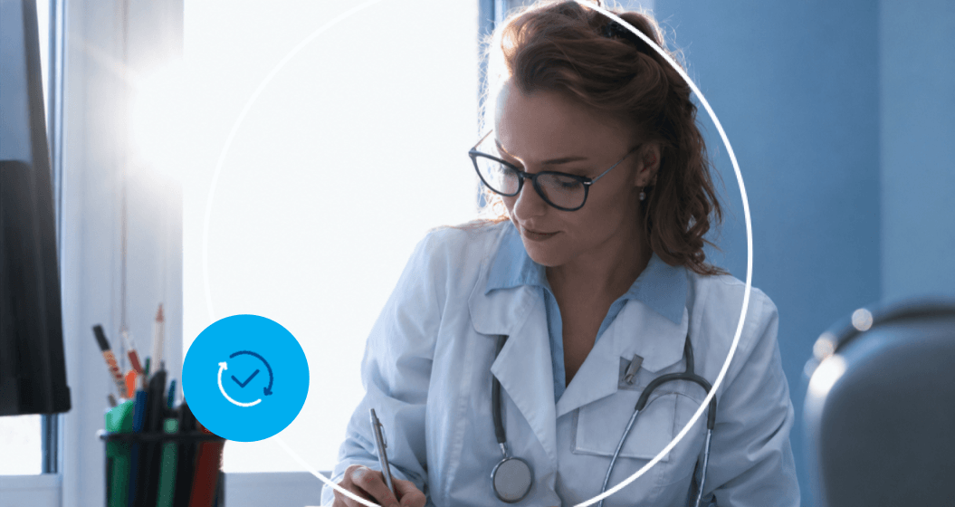 Médica preenchendo prontuário durante atendimento em consultório com estetoscópio e jaleco.