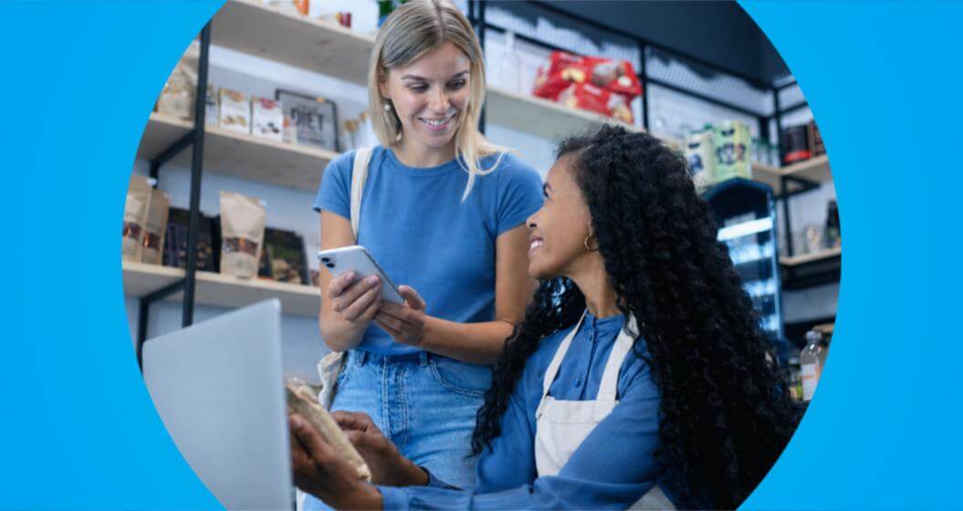 Empreendedora atende uma cliente usando ferramentas digitais, representando plataformas para receber pagamentos via Pix.